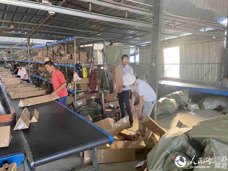 在堰下村“快递一条街”的快递揽收点，人们忙着把订单打包、装货。胡道兵摄