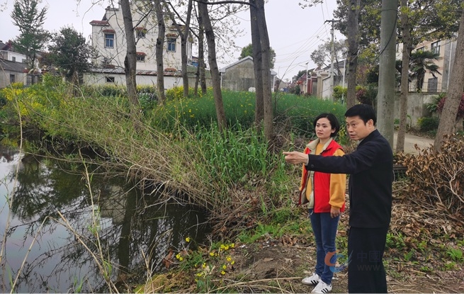 网格员上下联动处理群众反映的排污问题。郭勇摄