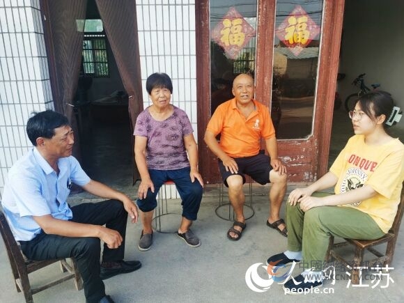街道民政助理蒋新（左一）到明圣楠家里走访。人民网记者王继亮摄