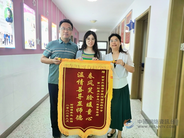  孩子转学后成绩有了较大进步，今年9月，姜坤琴向老师们送上锦旗。建宣摄