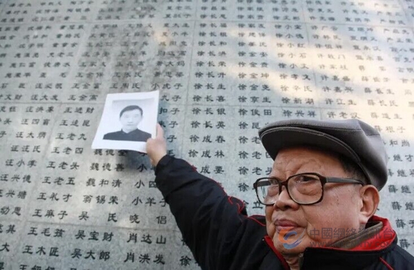 老人把哥哥的遗像带到“哭墙”前。图片来自侵华日军南京大屠杀遇难同胞纪念馆微信公众号