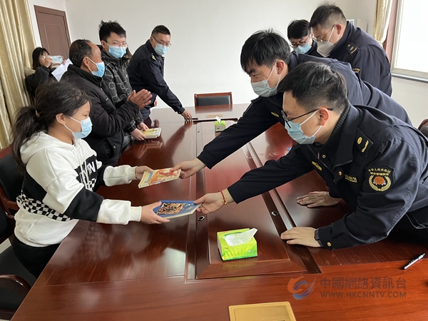 图为城管队员向儿童赠书。六合城管局供图