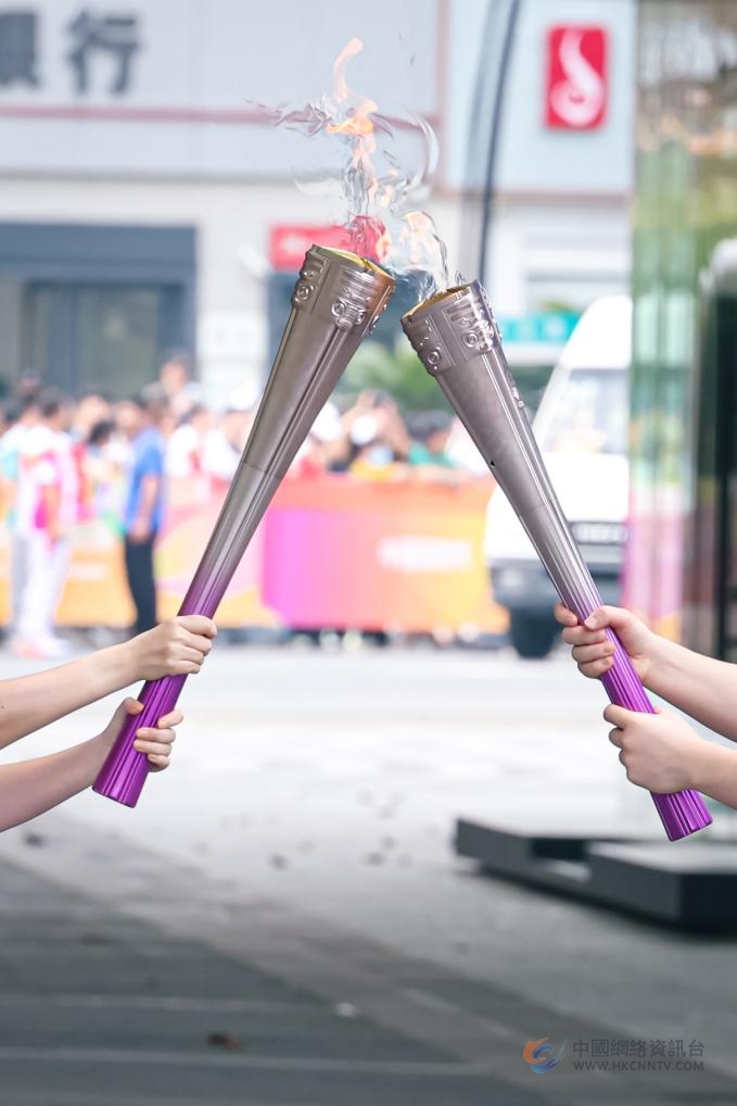 　　2023年9月8日，亚运火炬手在火炬传递中交接。新华社记者 江汉 摄