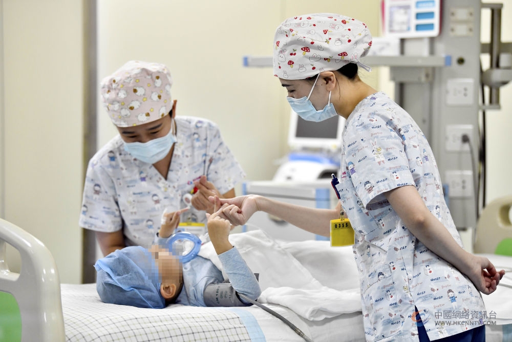 在山东省枣庄市妇幼保健院儿童ICU病房，医护人员为完成靶向治疗药物诺西那生钠的4岁脊髓性肌萎缩症患儿加油鼓劲（2022年1月1日摄）。诺西那生钠注射液是我国首个获批治疗脊髓性肌萎缩症的进口药物，2019年进入中国市场时，每针价格近70万元。在2021年国家医保目录药品谈判中，以3.3万元每针的价格进入新版医保药品目录。新华社记者 郭绪雷 摄